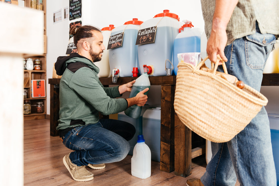 Tendero rellena envase de cliente en tienda a granel. El comercio sostenible es un gran emprendimiento en México